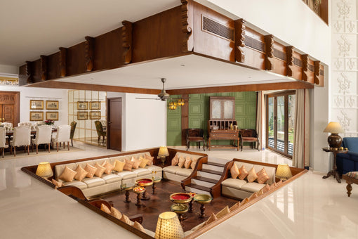 Sunken living room at Coromandel Court, Bengaluru, with built-in seating and handcrafted wooden tables by Temple Town
