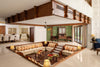 Sunken living room at Coromandel Court, Bengaluru, with built-in seating and handcrafted wooden tables by Temple Town